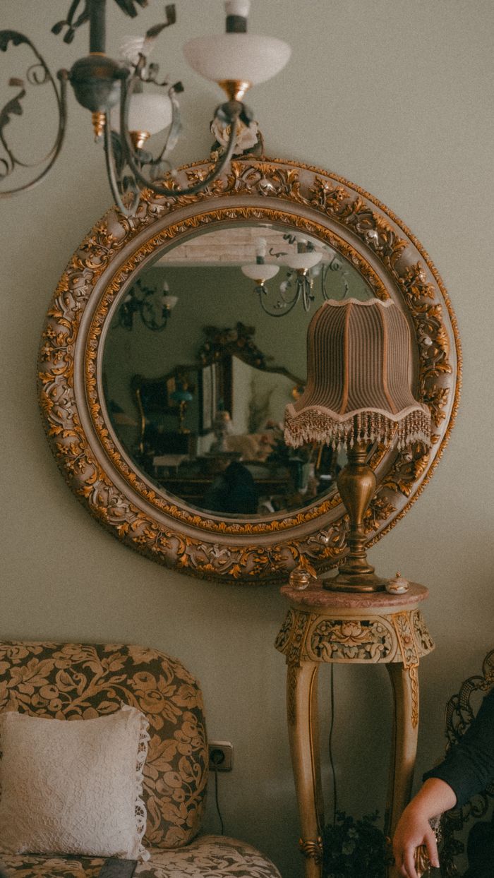 Stylish vintage interior featuring an ornate mirror, classic furniture, and elegant lighting.