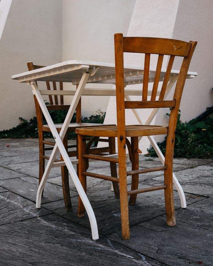 The Art of Drawing Readers In: Your attractive post title goes here Outdoor scene with wooden chairs and a foldable table on stone pavement.